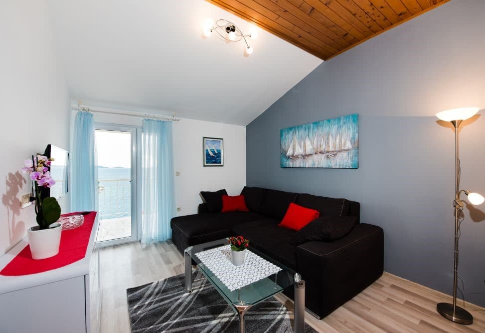 Comfortable living room with dark sofa and sailboat artwork